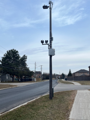 Tall poll with camera devices on a residential street at a corner